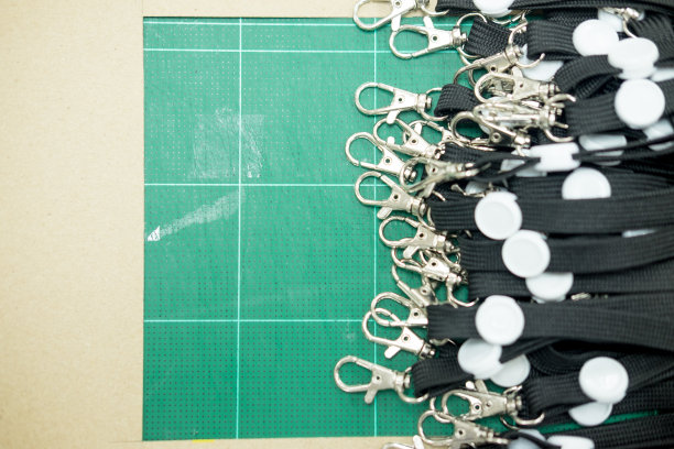 绿色桌子上的黑色系带，带钩作徽章标签图片下载