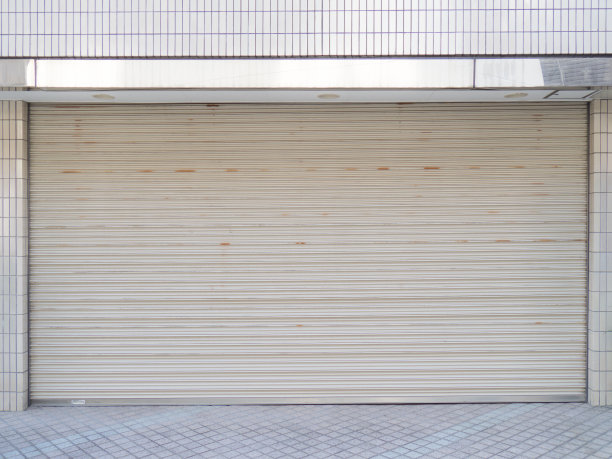 A white closed shutter on the street of a store or garage 閉じられた店舗・ガレージのシャッター图片下载
