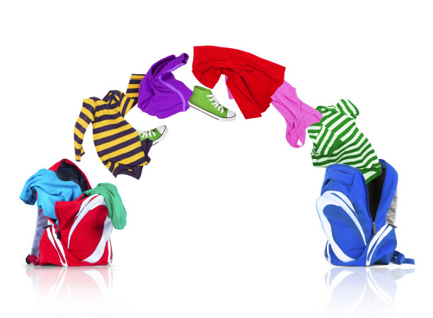 五颜六色的衣服从背包里飞出来，落入另一个白色背景的背包里图片下载