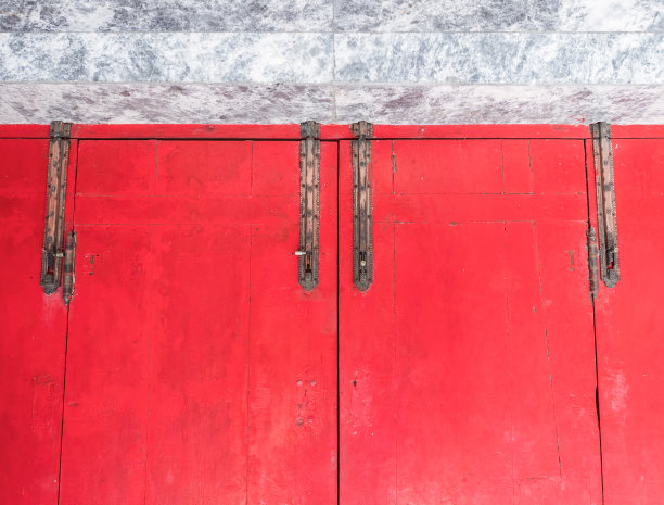 红色木门的旧黄铜门闩。图片下载
