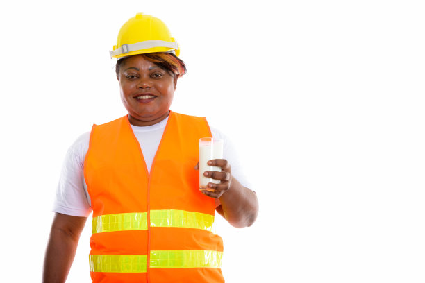 这张照片拍摄的是一名快乐的大码非洲黑人建筑女工，微笑着拿着一杯牛奶图片下载