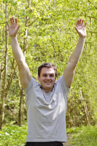 快乐快乐的人在公园里高高举起双手，胜利，胜利，灿烂多彩图片下载