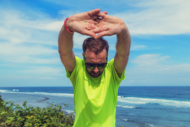 在海边慢跑/锻炼后做伸展运动。图片下载