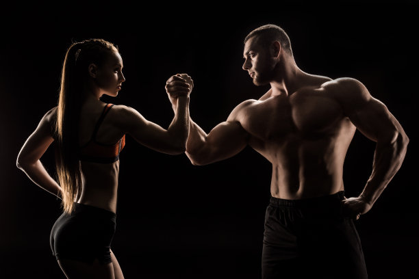 年轻的运动夫妇手拉手孤立在黑色图片下载
