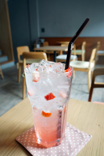 特写的冰玫瑰意大利苏打水柠檬和新鲜草莓在木桌上。图片下载