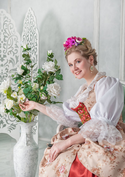 漂亮的女人穿着老式的中世纪服装坐在沙发上图片下载