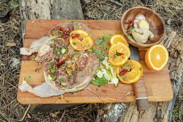 美味多汁的腌鸡肉放在切菜板上。图片下载