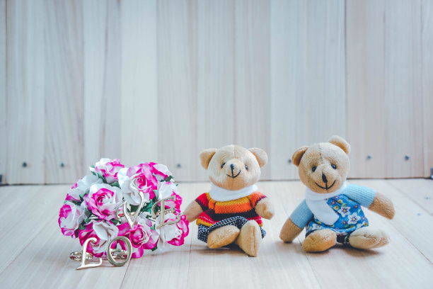 爱的信息装饰在玫瑰花束附近一对可爱的夫妇拥抱熊在爱。爱情和浪漫的概念。图片下载