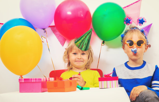 快乐的小女孩和男孩在生日聚会上拿着礼物图片下载