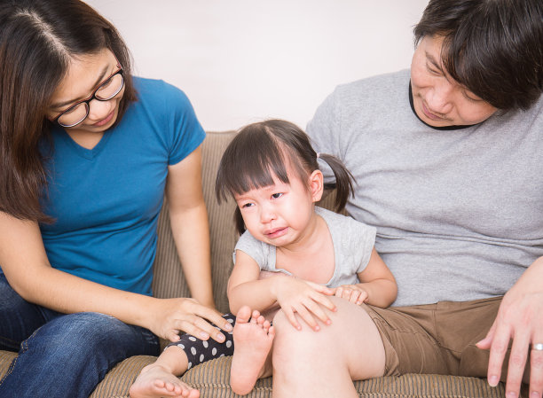 父母安抚哭泣的女孩图片下载