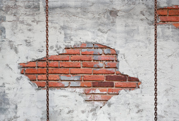 链条在旧砖墙的背景上摆动。图片下载