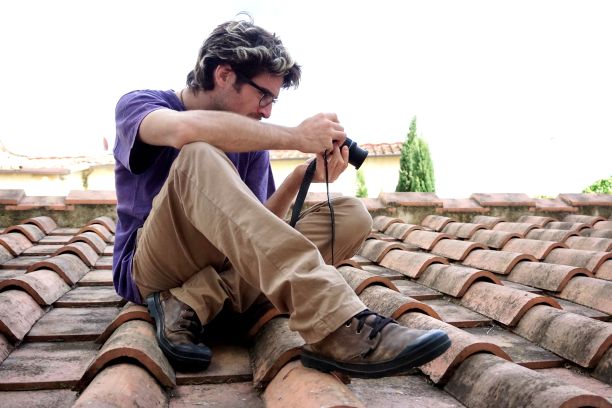 一个年轻的成年人在屋顶上拍照图片下载