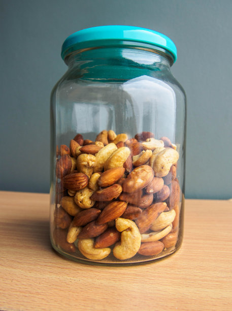 木桌上的瓶子里装着杏仁和腰果图片下载
