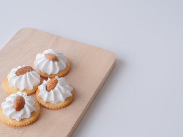 杏仁饼干在木板上，白色的背景。图片下载