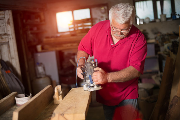 木工手刨在一个老木匠的手中。图片下载