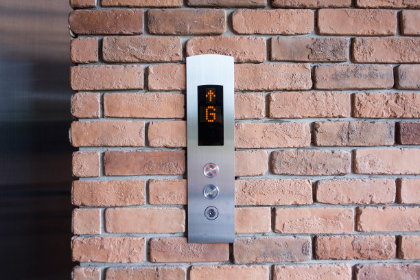 电梯按钮显示G层和向上的箭头。在古老的红砖墙上图片下载