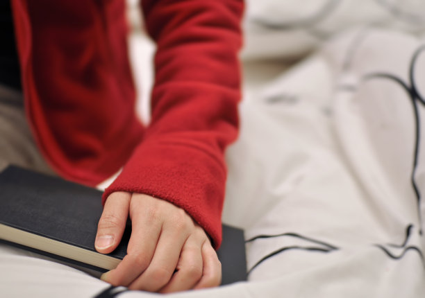 女人在床上拿着书图片下载