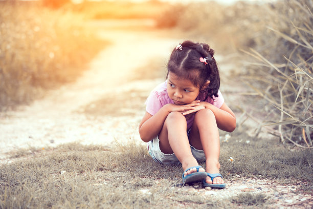 孤独而悲伤的小女孩坐在古色古香的公园里图片下载
