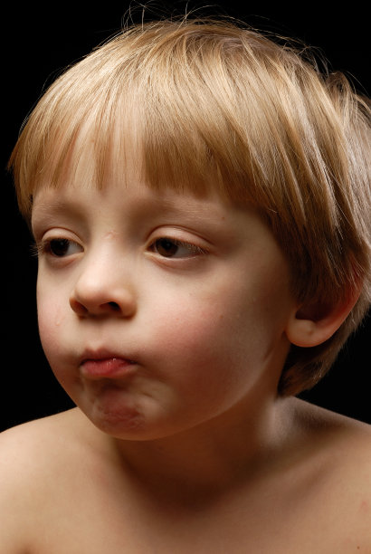 小男孩的特写看着旁边咬嘴唇图片下载