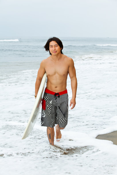 冲浪者背着他的冲浪板图片下载