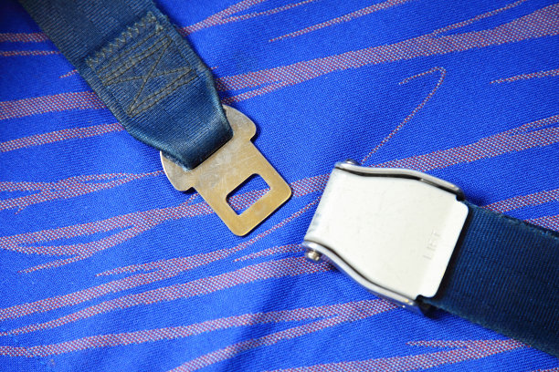 在飞机上系安全带，有蓝色座椅图片下载