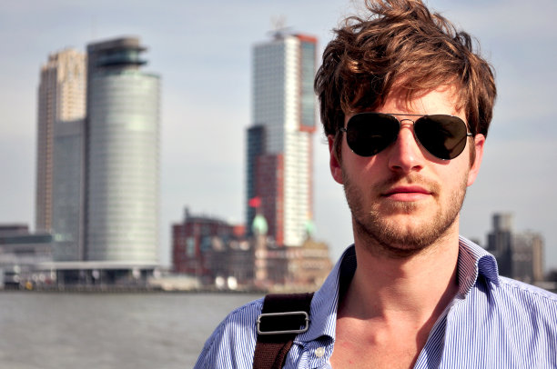 英俊的年轻人站在鹿特丹的地平线前图片下载