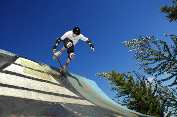 在户外坡道上运动的滑板运动员图片下载