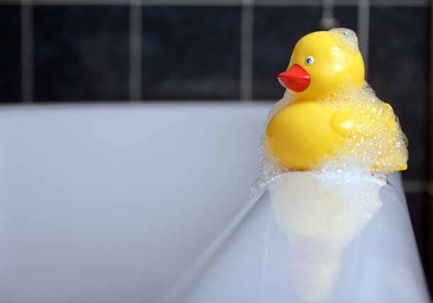 泡泡橡皮鸭坐在浴边图片下载