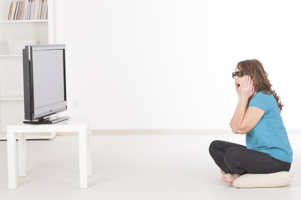 戴着眼镜看3D电视的女人图片下载