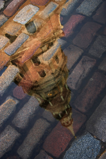 雨后的水坑里倒影着古城图片下载