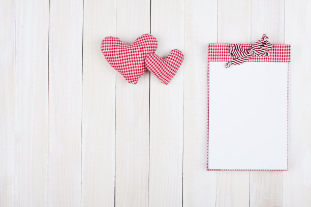 两颗心和笔记本在白木背景上图片下载