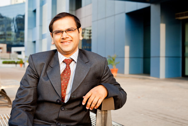 一位自信开朗的印度商人站在办公大楼前图片下载