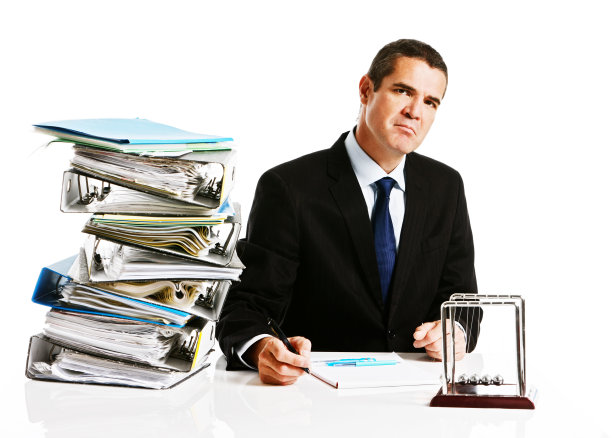 面对堆满文件的办公桌，脾气暴躁的商人皱起了眉头图片下载