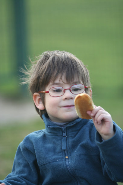 戴眼镜的男孩看着蛋糕图片下载