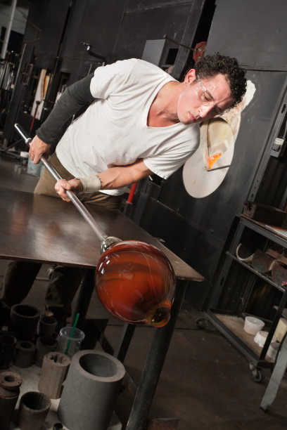 一个男人正在检查他的玻璃花瓶图片下载