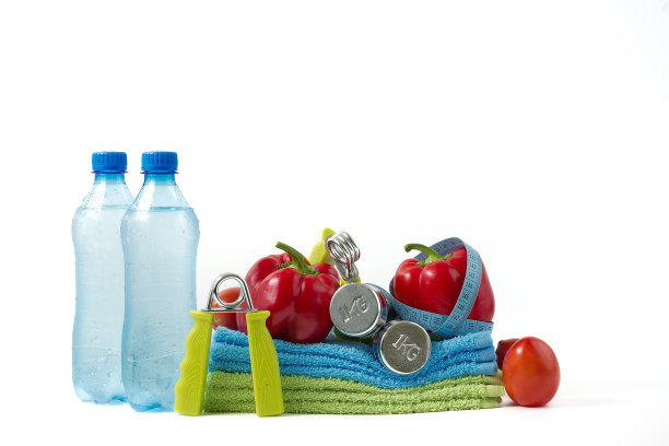 白色背景上的蔬菜和水的健身哑铃。图片下载