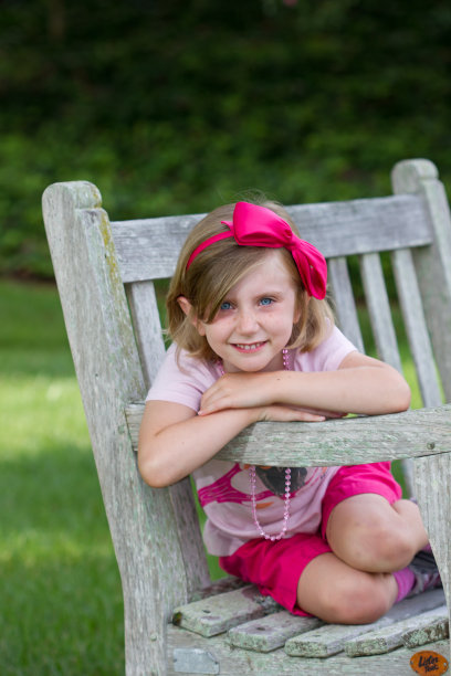 在公园长椅上摆姿势的女孩图片下载