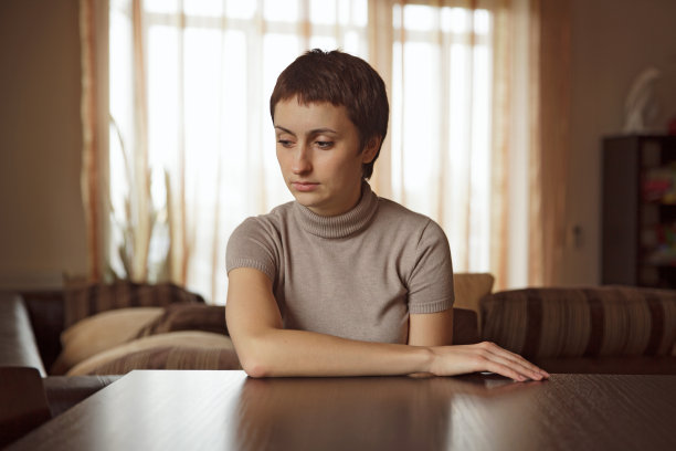 美丽悲伤的女人坐在桌旁图片下载