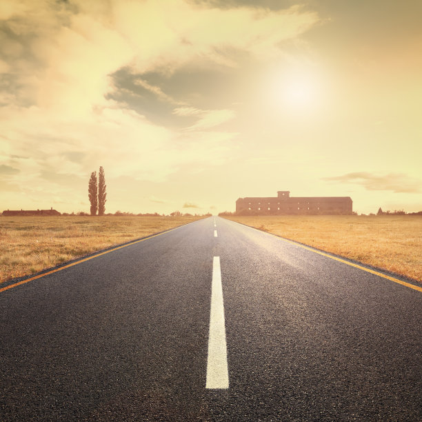 夕阳西下，在柏油路上朝着太阳行驶图片下载