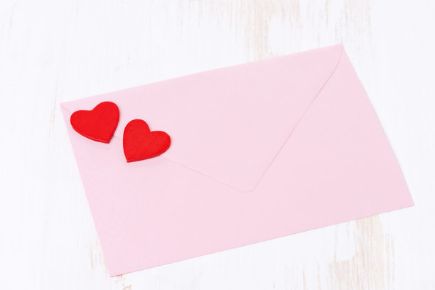 白色木质背景上有红心的粉色信封图片下载