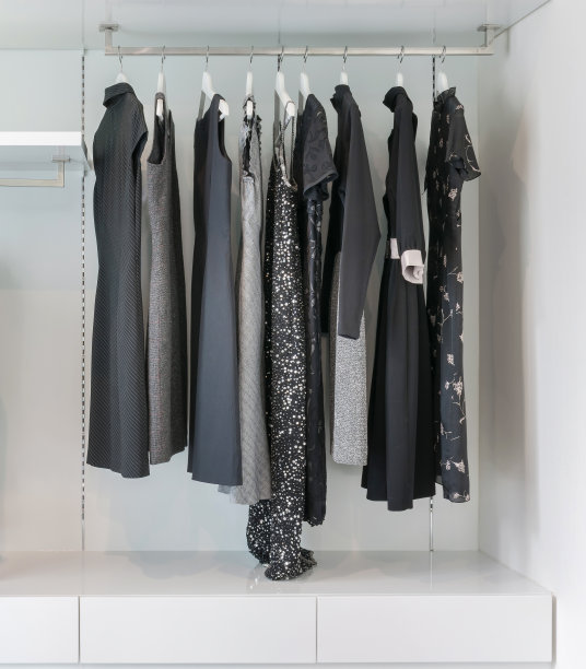 一排黑色连衣裙挂在白色衣柜里的现代衣柜。图片下载