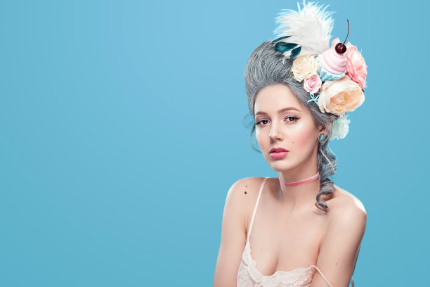 头上戴着花的金发美女。甜美性感的女士。复古风格。时尚照片上的蓝色背景与复制空间图片下载