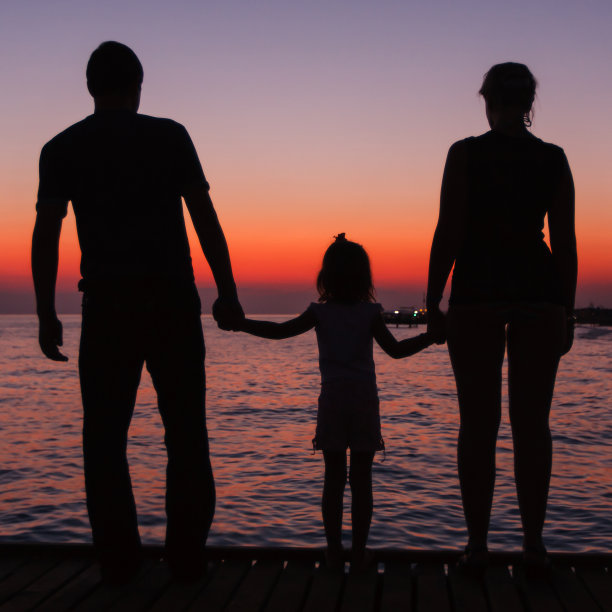 夕阳下男人、女人和孩子的剪影图片下载