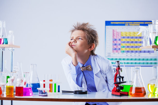 沉思可爱的男孩摆姿势在化学设备图片下载