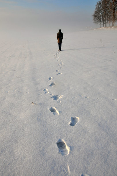雪地里有远方的人和鞋印。图片下载