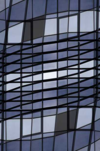 网格结构。玻璃墙壁反射蓝色天空的重制照片。抽象的现代建筑，技术或工业背景在色调的蓝色。图片下载