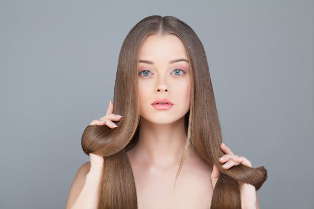 美丽的女人与长棕色头发在黑色的背景素材图片