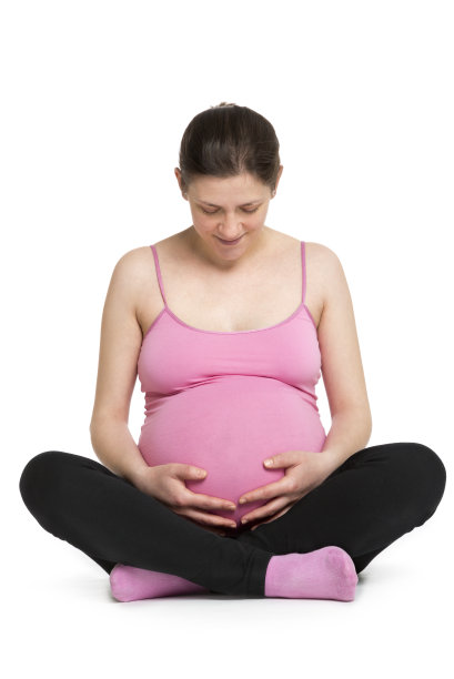 年轻的孕妇手放在肚子上。图片下载