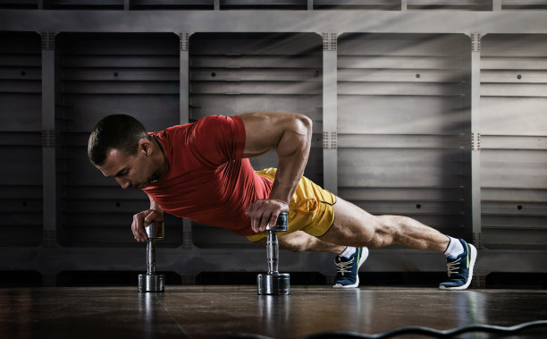 运动。帅哥在健身房里单手做俯卧撑图片下载