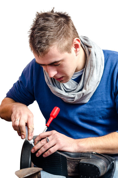 年轻的鞋匠正在修补一双旧鞋图片下载